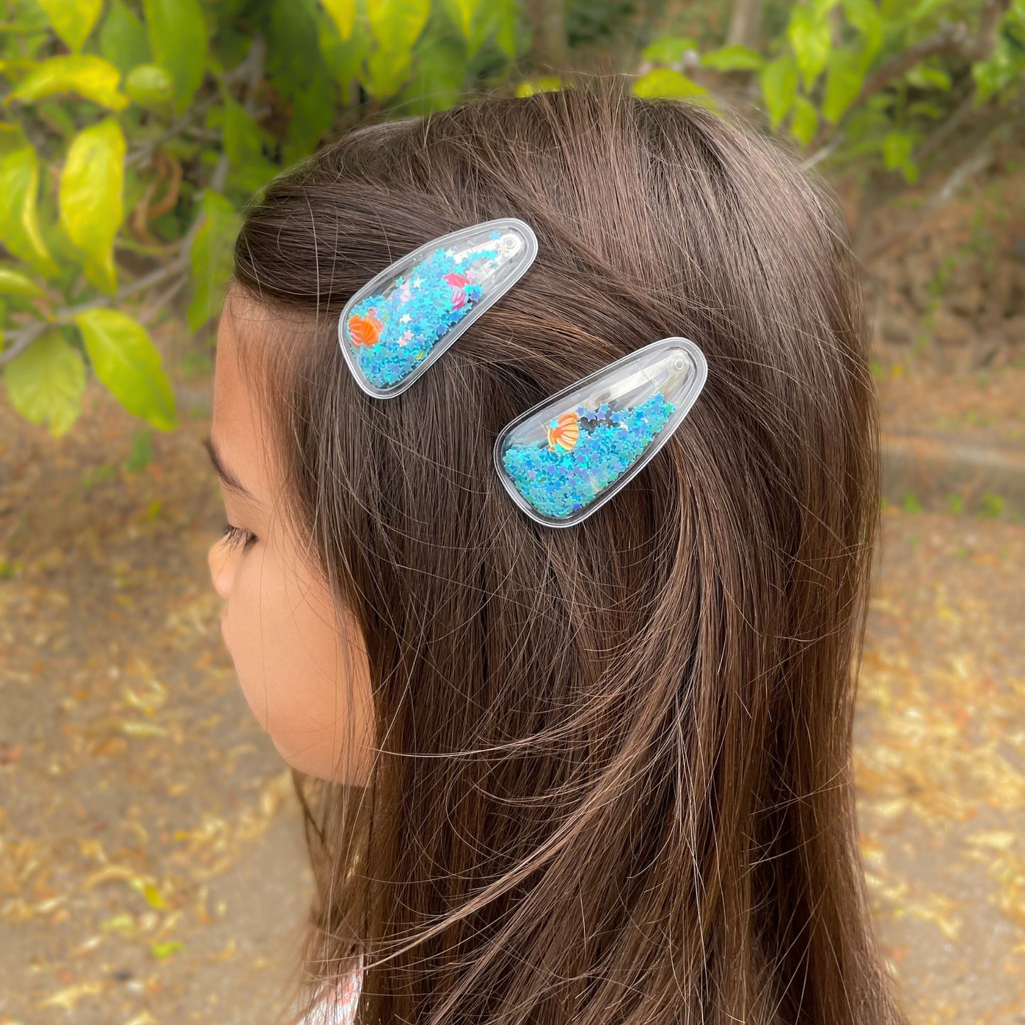 Seashell-filled confetti hair clips for kids, a fun lively accessory that shakes and brightens up any outfit.