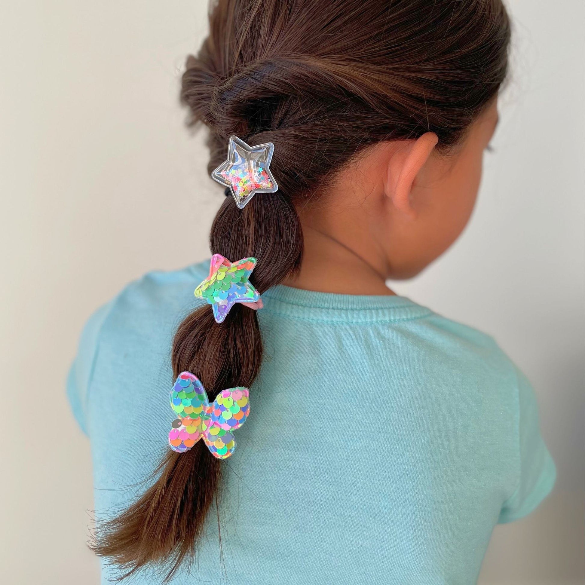 Rainbow kids butterfly sparkly sequin hair tie, designed to securely hold hair while adding sparkle and style to any look. 