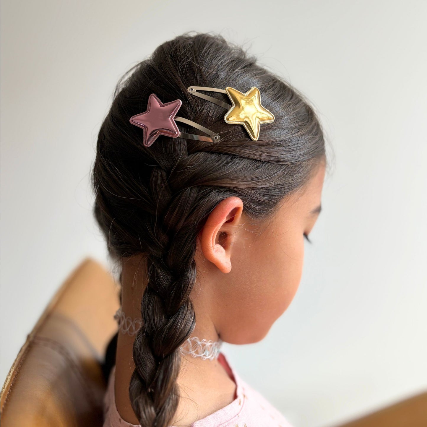 Celestial-inspired metallic snap clips shaped like stars, ideal for adding glam to any hairdo.