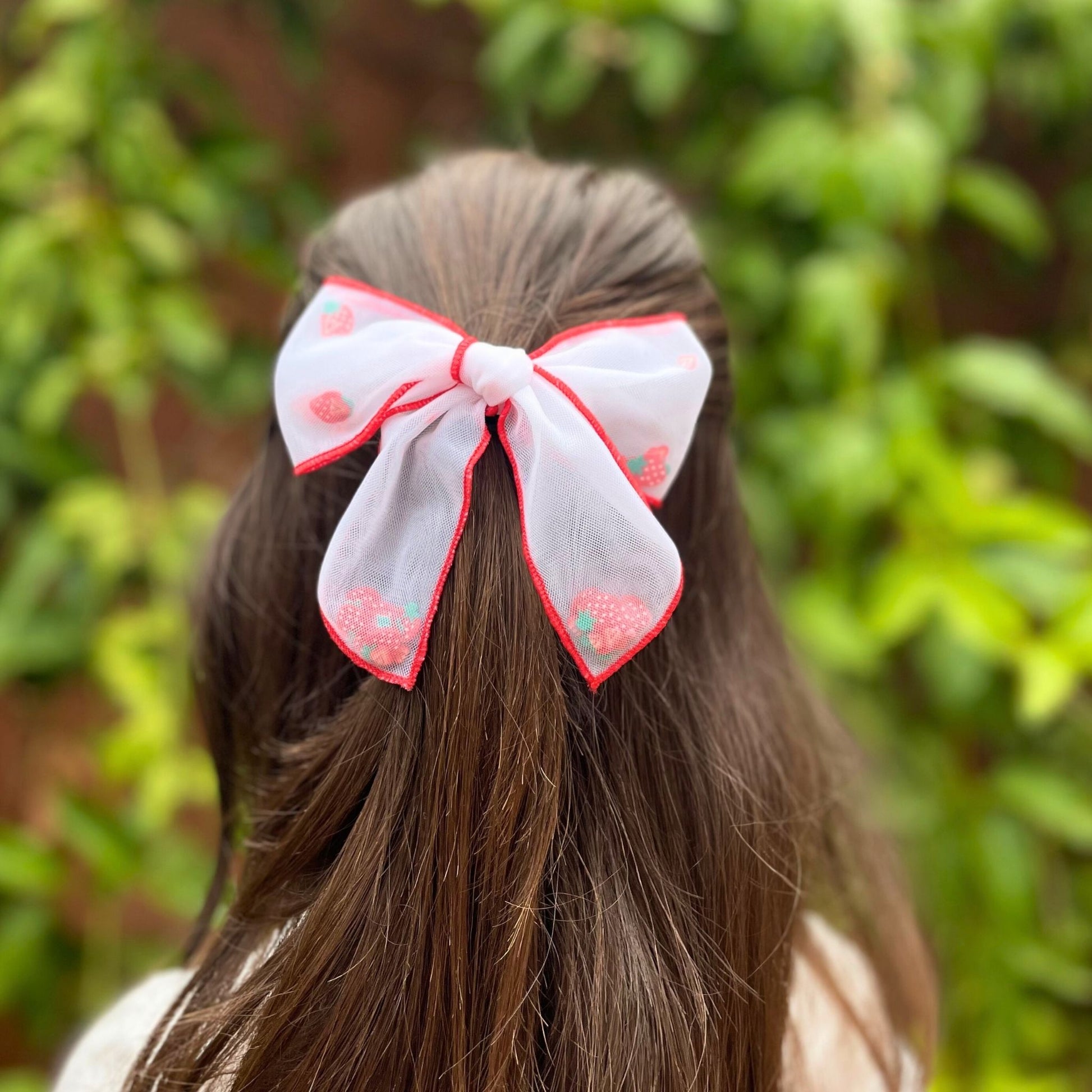 Playful kids strawberry confetti mesh hair bow, perfect for adding flair to any hairstyle and great for all occasions.