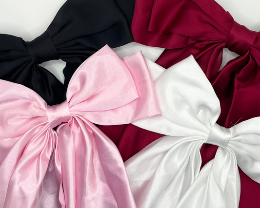 Elegant satin hair bow, crafted from soft, sleek fabric, a beautiful accessory for enhancing any hairstyle.